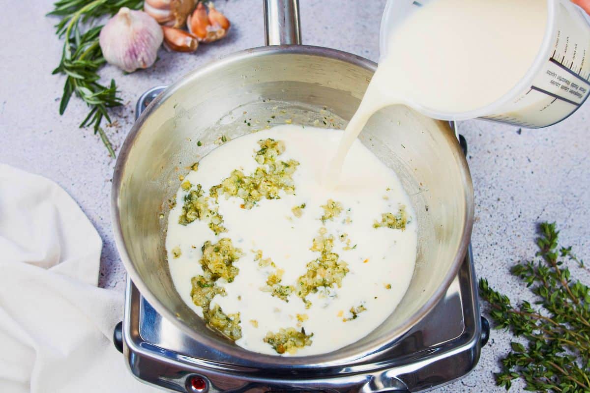 non dairy milk being poured into saucepan with vegetables