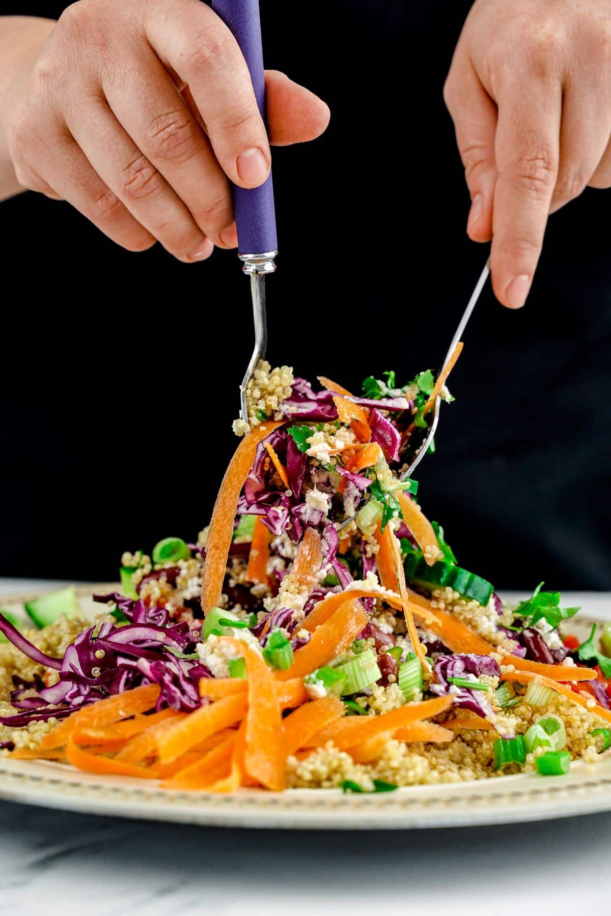 forks tossing salad above plate