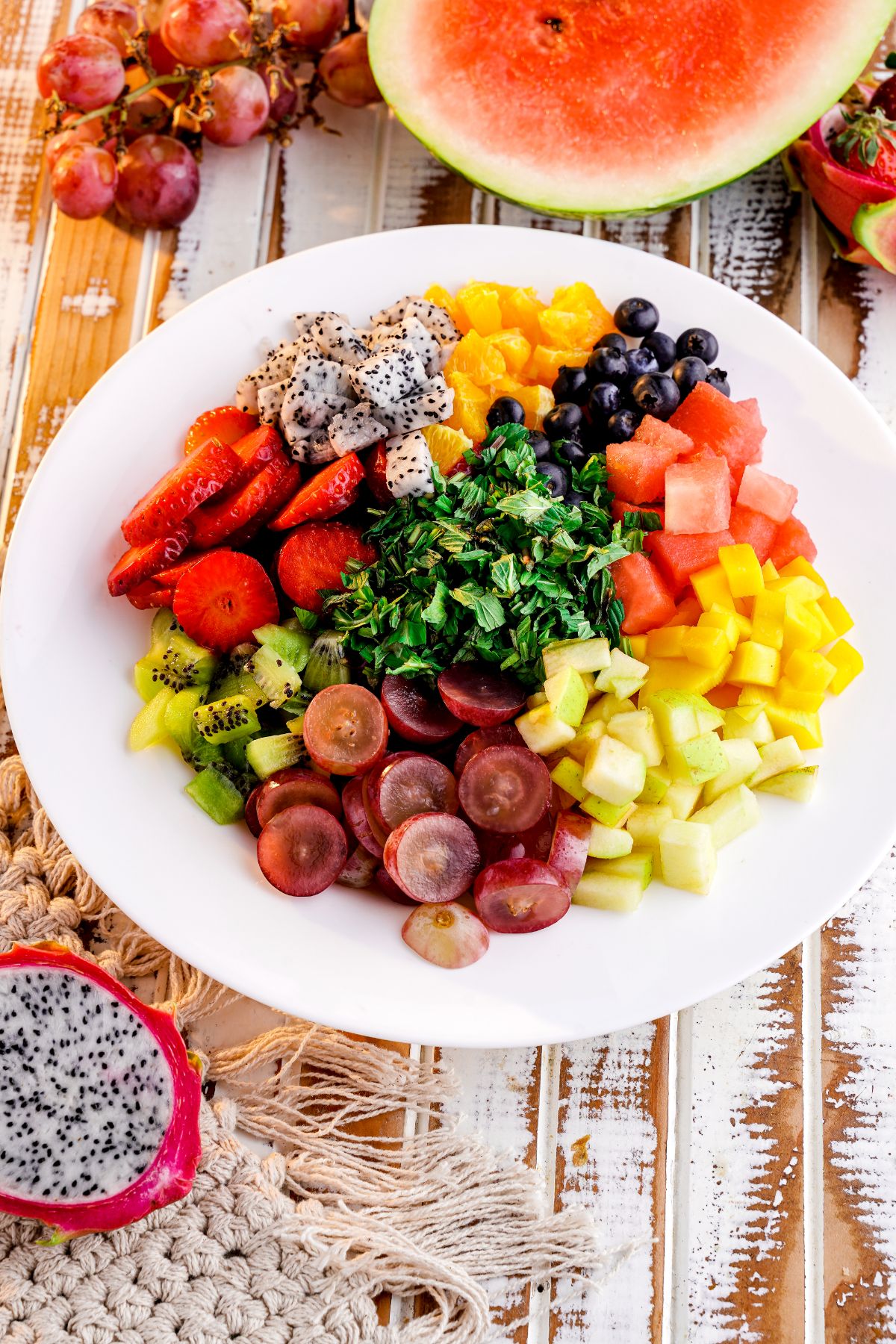 white bowl of fruit salad on wood table