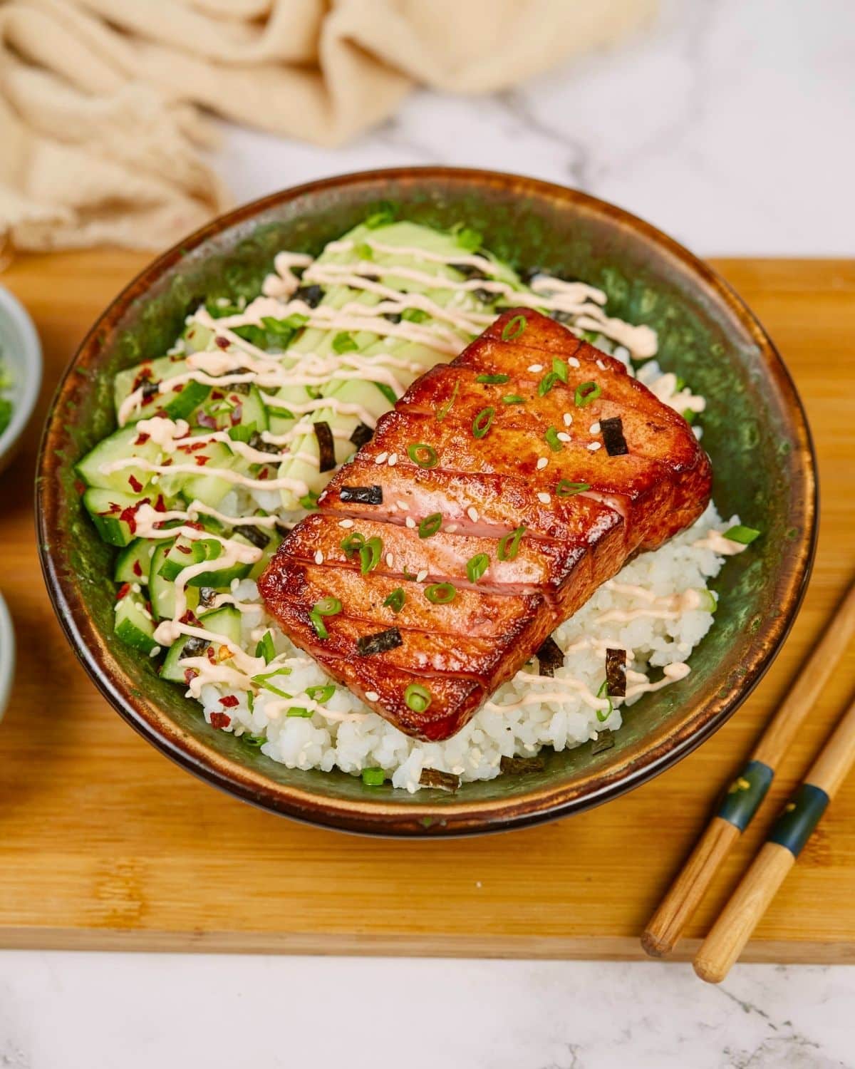 large green bowl of rice topped with vegan tofu salmon