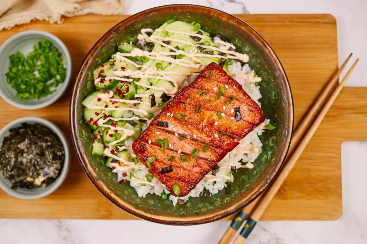 tofu salmon slice on top of green bowl of rice
