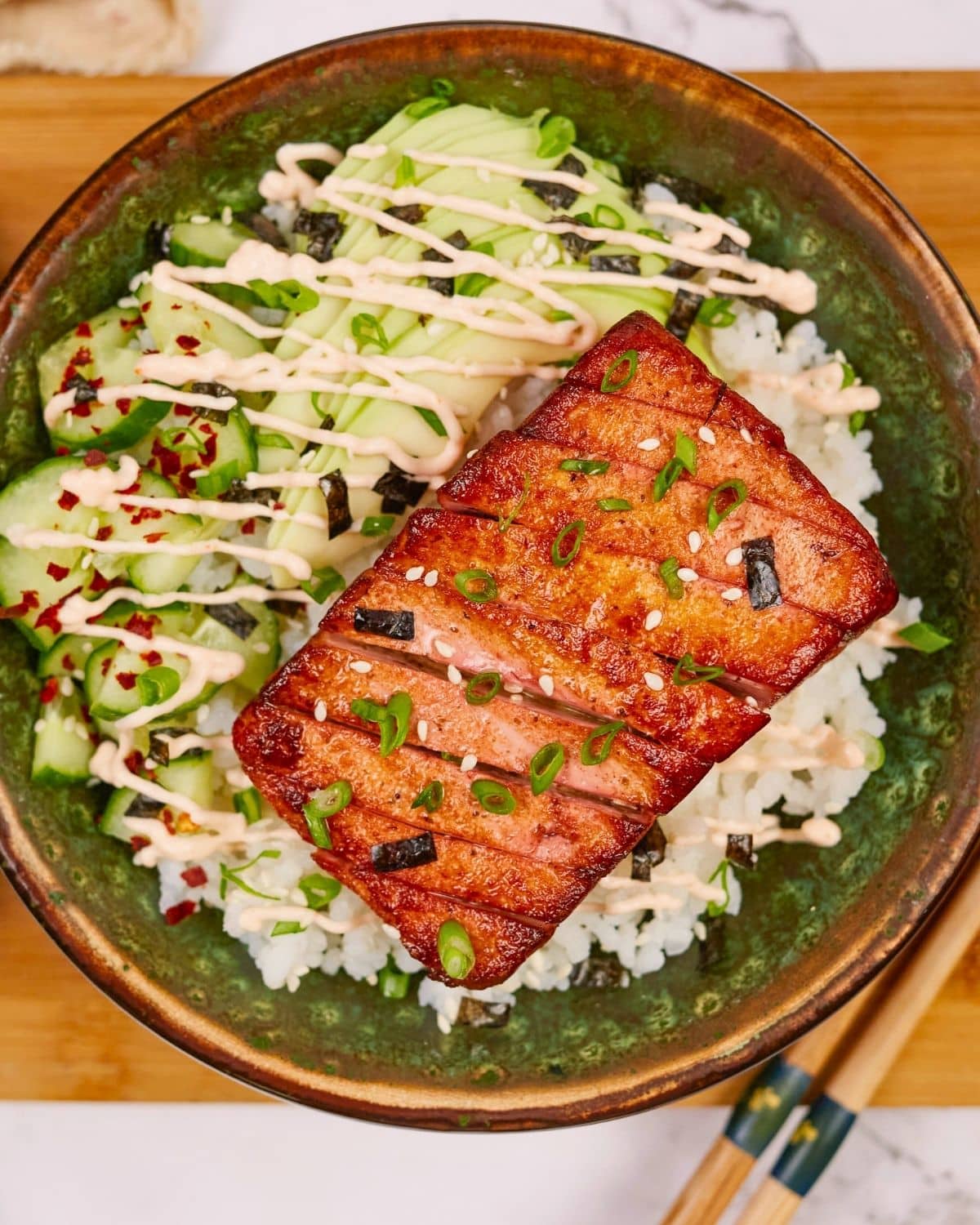 grenn tofu salmon rice bowl on top of wooden board