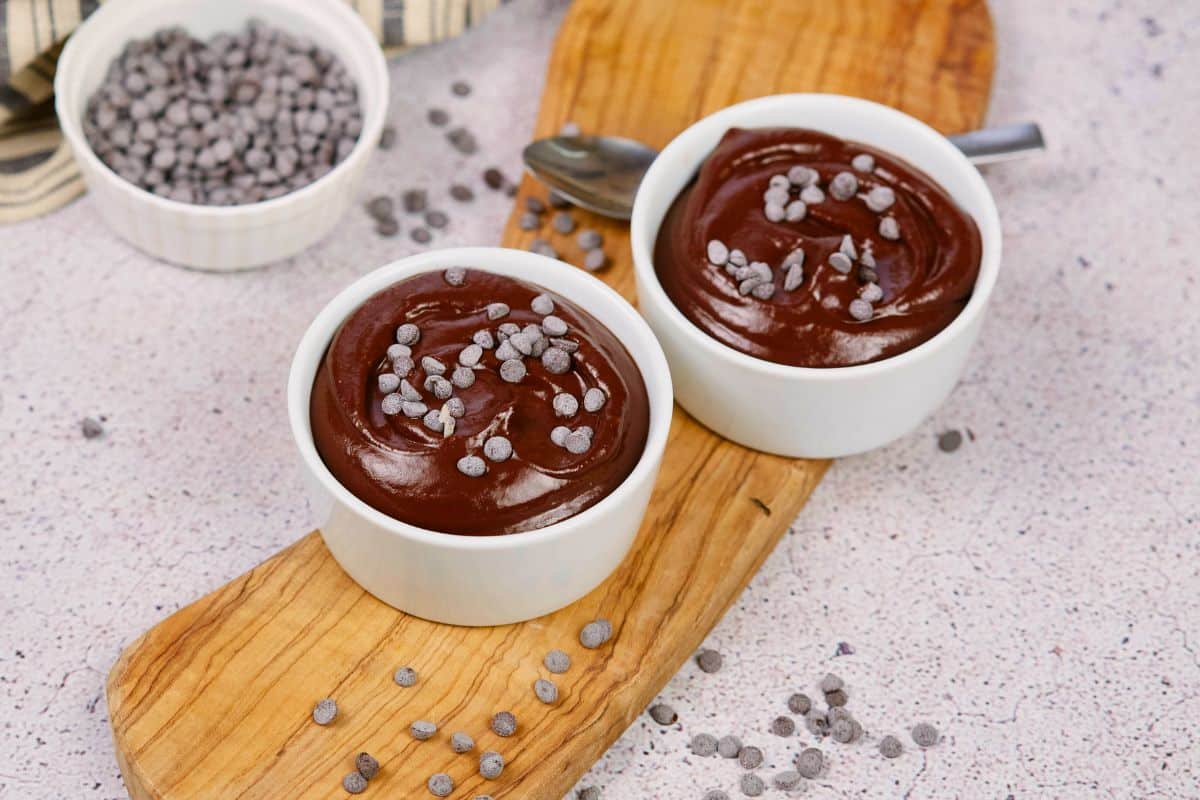 bowls of pudding on table next to bowl of chocolate chips