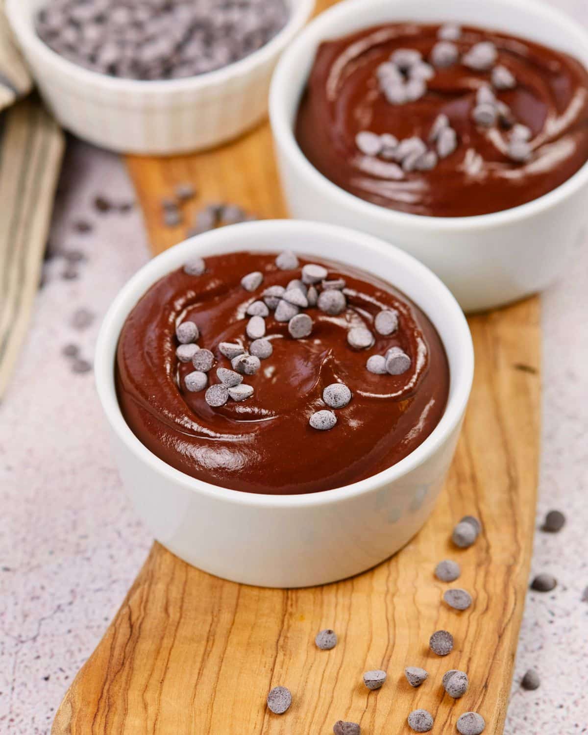 two ramekins of pudding on wooden board