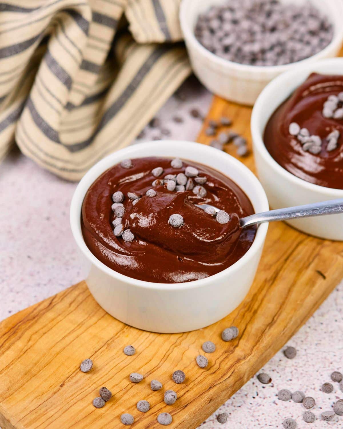 spoon holding bite of vegan chocolate pudding above bowl