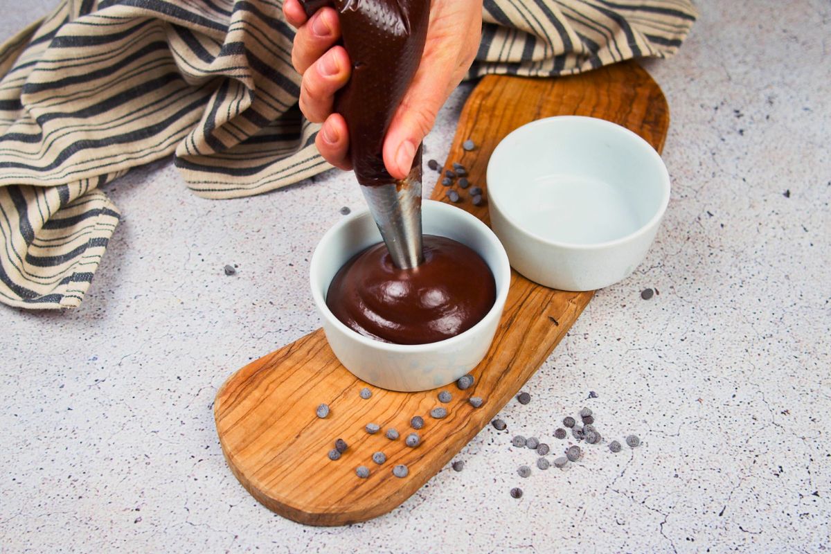 pudding being piped into ramekin