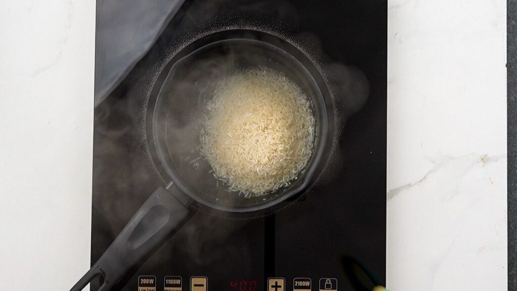 rice cooking in saucepan on hot plate