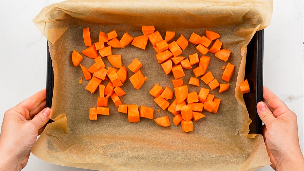 sweet potato cubes on parchment lined baking sheet