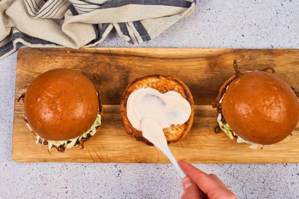 mayonnaise being spread onto bun
