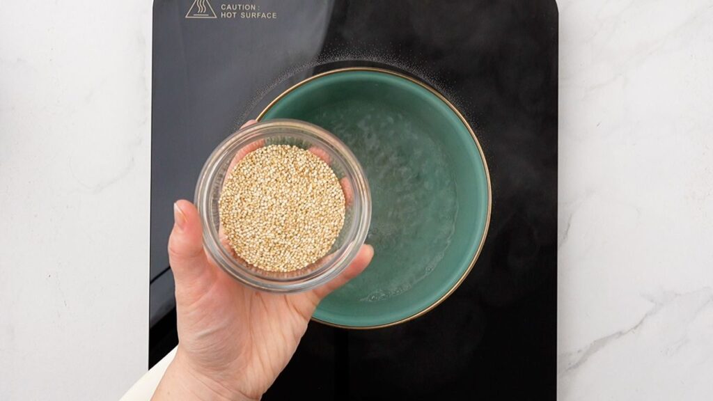 quinoa being added to teal saucepan