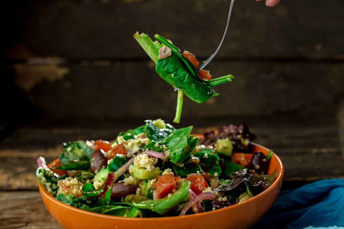 fork of salad held above bowl