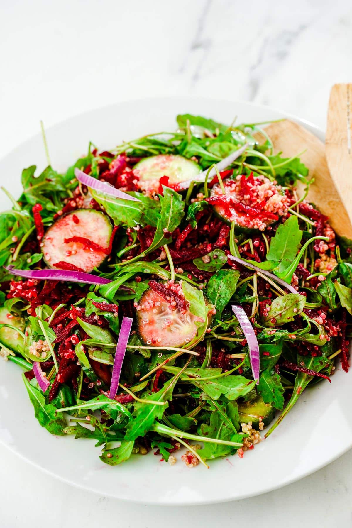 white plate of salad with beets and cucumbers